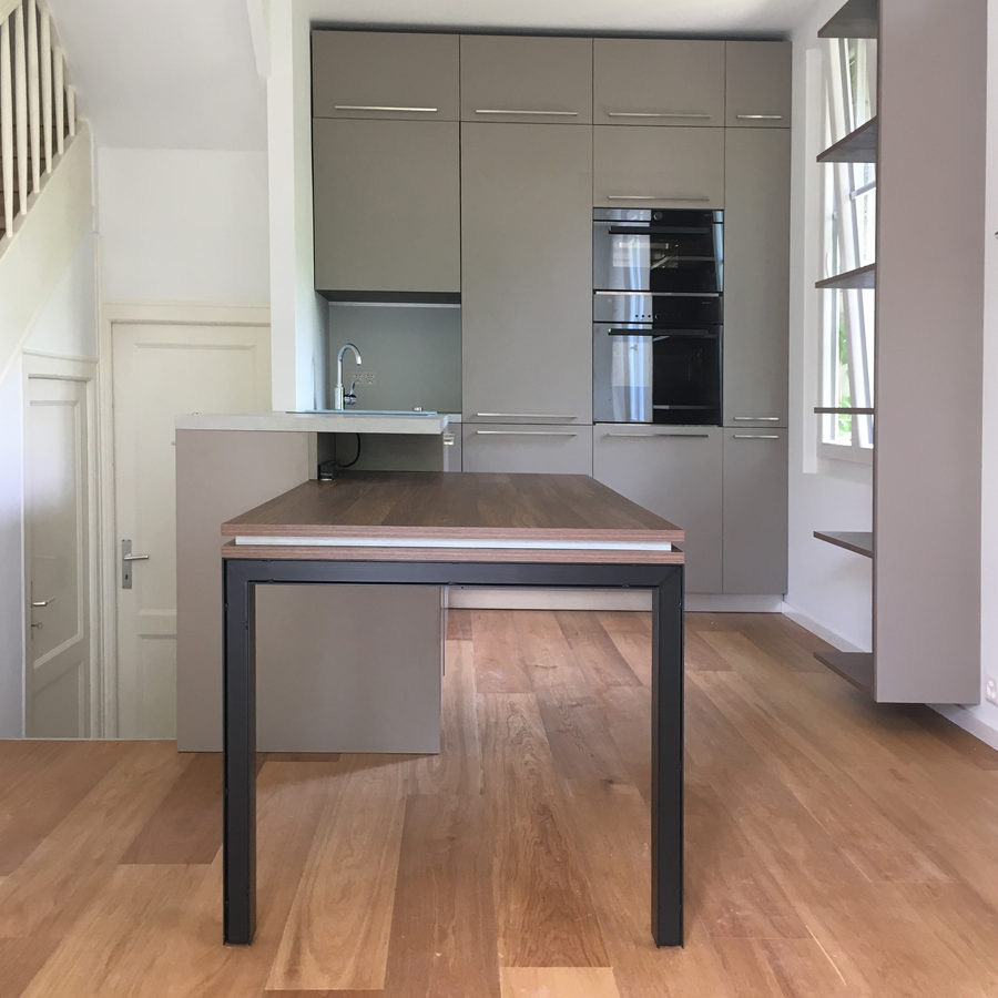 Cuisine ouverte gris clair avec îlot et table intégrée
